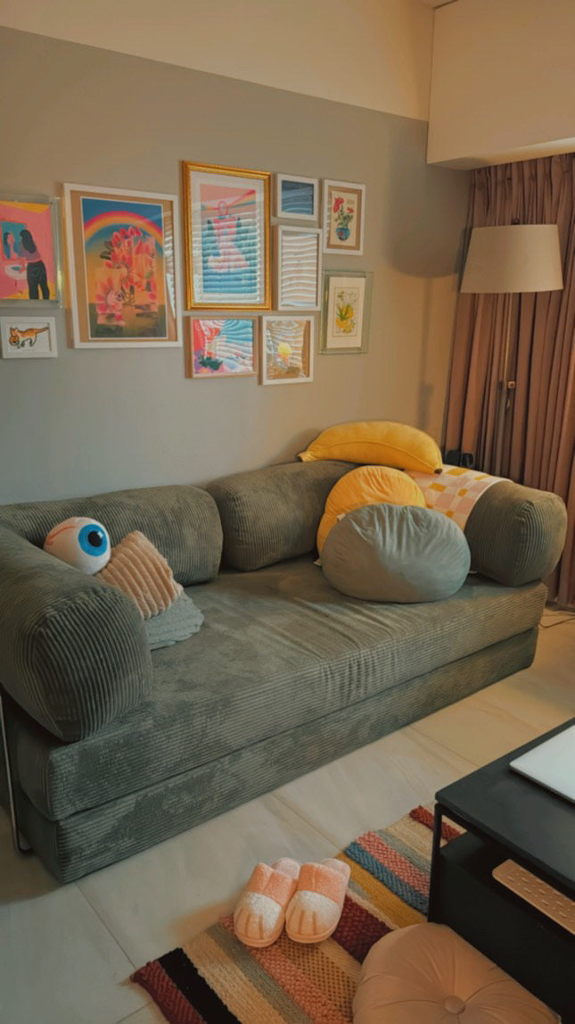 Olive green Teddy sofa styled with round pillows, wall art gallery, and cozy living room decor from Home Hues