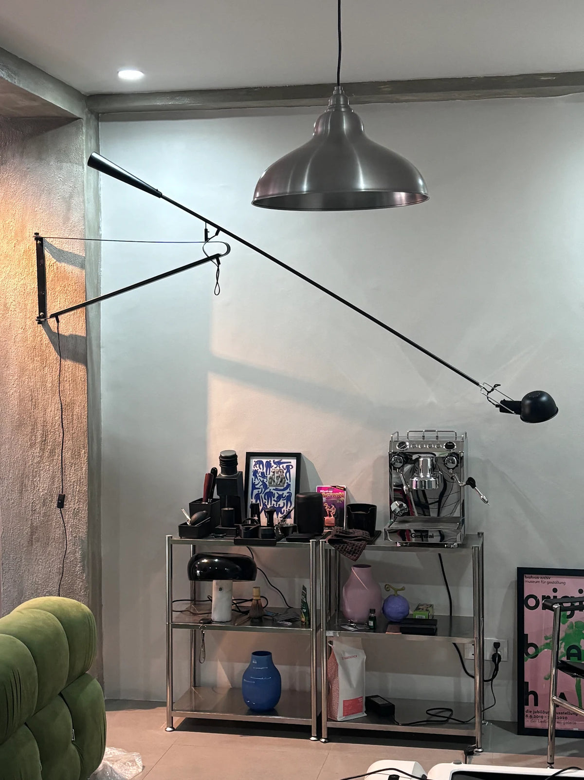 Modern industrial living space with 265 wall lamp, stainless steel shelving, espresso machine, and eclectic home decor from Home Hues